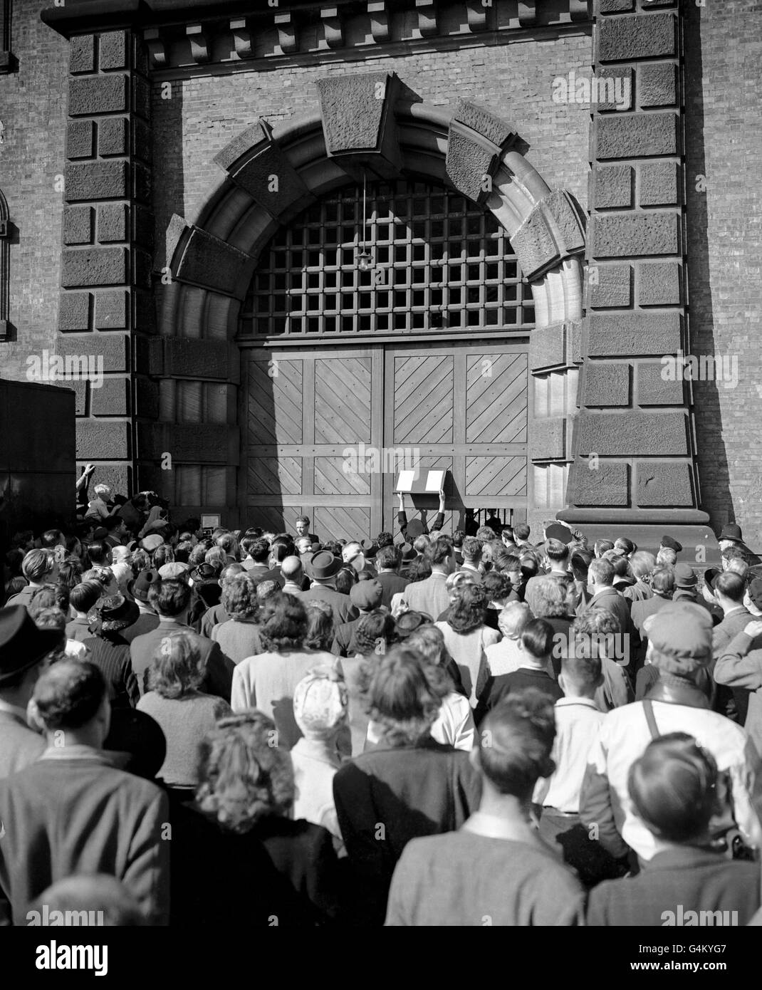 A crowd gathered outside the gates of Wandsworth prison to read the notices posted on the doors of Wandsworth Prison, London, following the execution of John George Haigh, 39, for the murder of Mrs Olivia Durand-Deacon, a 69-year-old Kensington Widow whose body was destroyed in an acid bath. Stock Photo