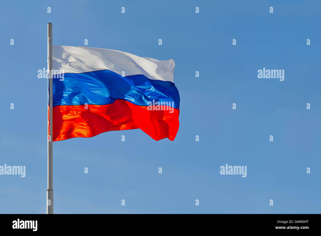 Russian flag is waving in front of blue sky Stock Photo