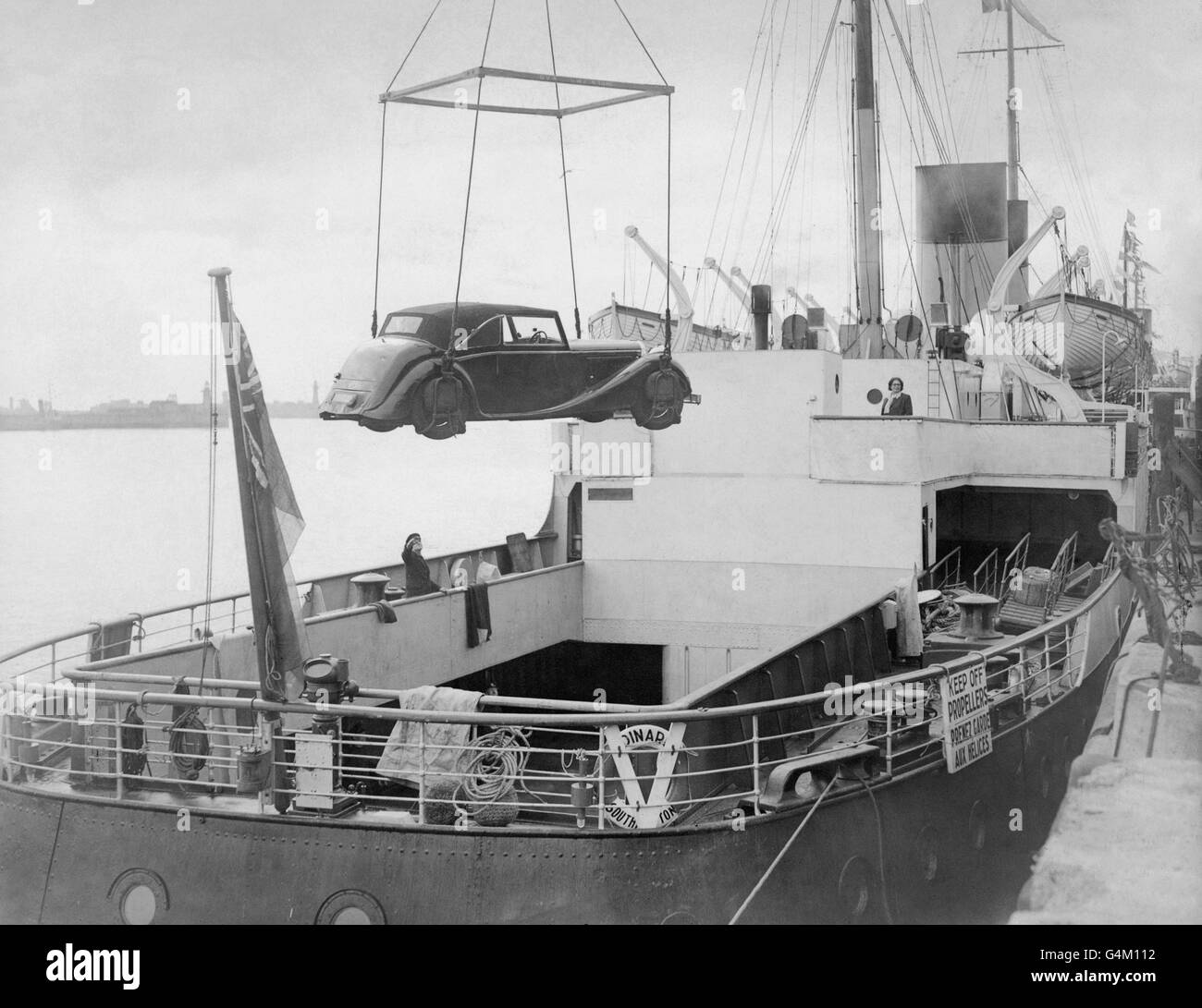 A private car is swung into the hold of the SS Dinard. The ship was formally a floating hospital after serving at Dunkirk and off the Normandy beaches during World War Two. She has now been converted to service as a car ferry between Dover and Boulogne, France, accommodating 80 cars and 300 passengers Stock Photo