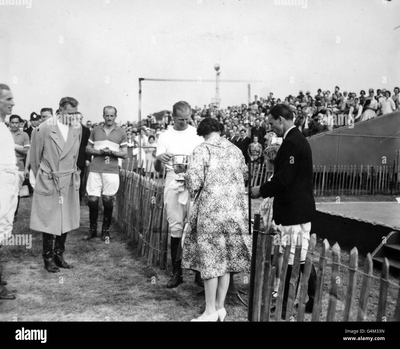 Queen Elizabeth II presents the trophy to the Duke of Edinburgh after he had captained the Windsor Park polo team to victory over Casarejo at Smith's Lawn, Windsor. Stock Photo