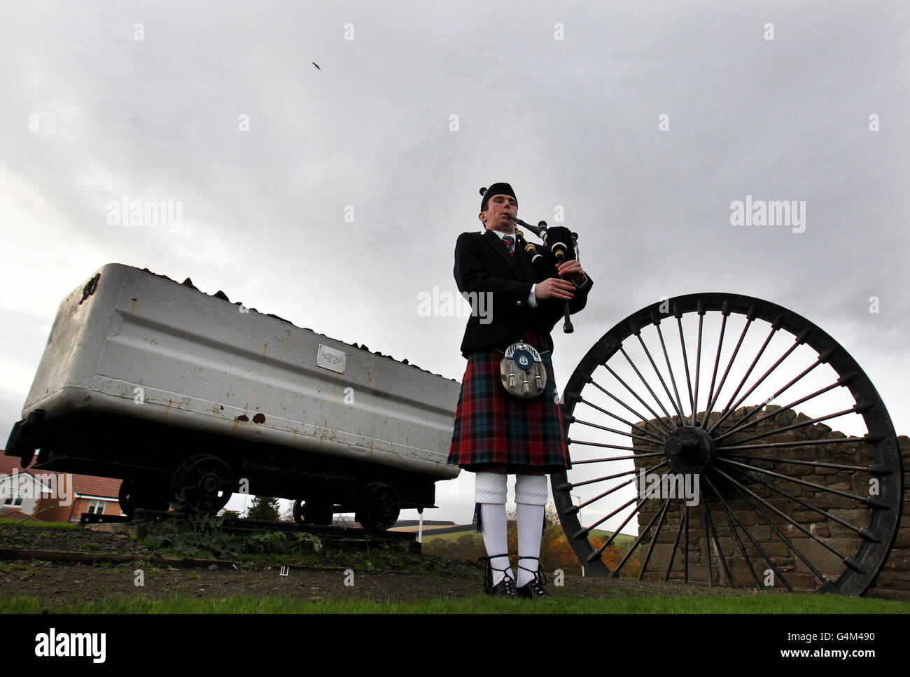 Walter Glendinning from Fife Police Pipe Band plays at the site of the Bowhill Collieries marking the 80th anniversary of the Scottish mining disaster where 10 men lost their lives. Stock Photo