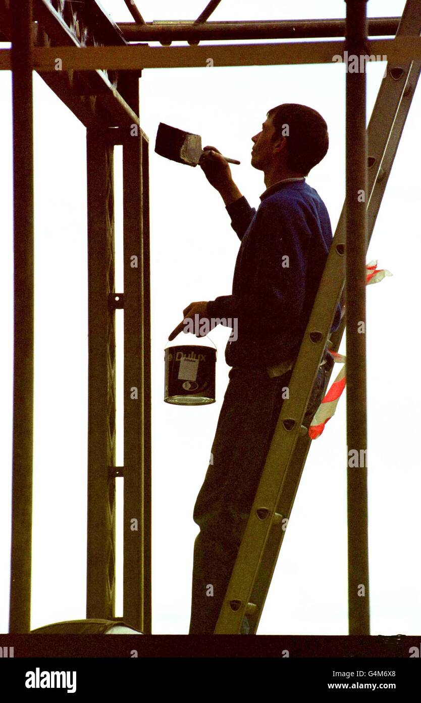 A painter starts work on the long job of painting the frames that will hold up a giant TV on the
