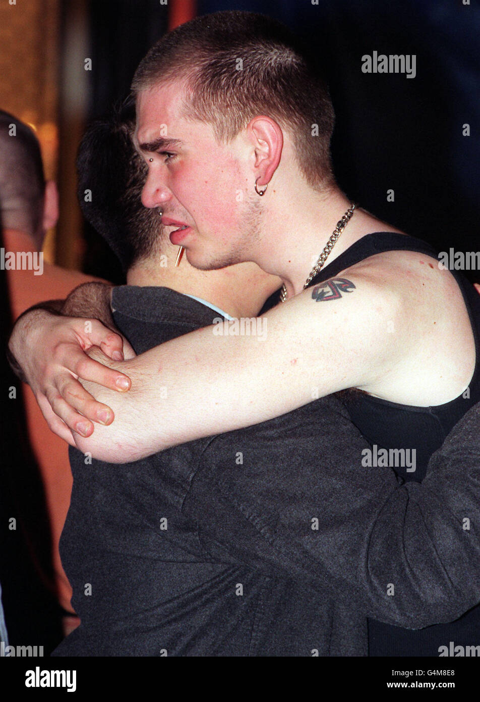 Two young men comfort each other when police allowed the general public to return to the bomb site at the Admiral Duncan pub in Old Compton Street, central London, 24 hours after a nail bomb took the lives of three people and injured many. * Twod ied at the scene and one later in hospital. Stock Photo
