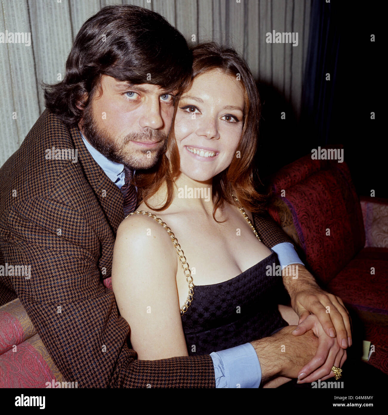 Oliver Reed embraces Diana Rigg at a London Hilton Hotel press reception for their latest film, 'The Assassination Bureau'. Stock Photo