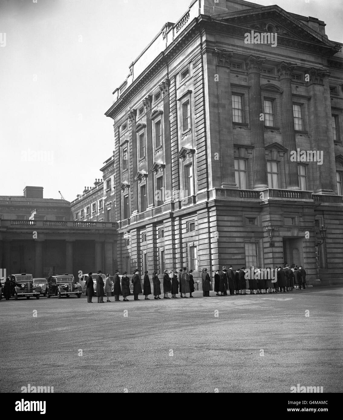 People queue to sign the visitors' book following the death of King George VI, at Buckingham Palace, London. Stock Photo