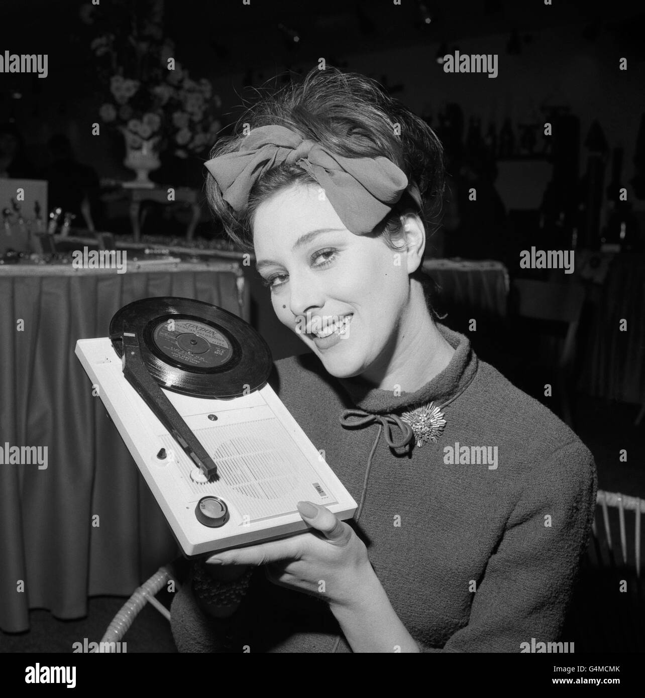 British actress Sue Lloyd, who has just finished her first film role in the spy drama 'The Ipcress File', which also stars Michael Caine, is seen holding a fully transistorised record player at Giftex International Gift and Fancy Goods Exhibition, held at the Alexandra Palace, London. Stock Photo