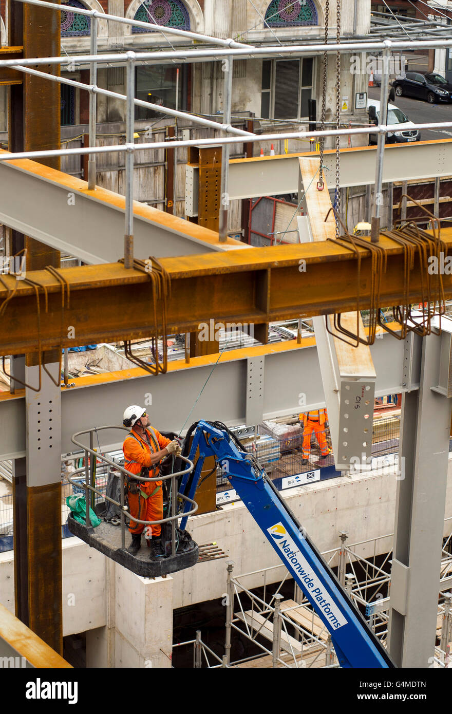 Construction worker in a hoist installing girders at the Eastern Ticket