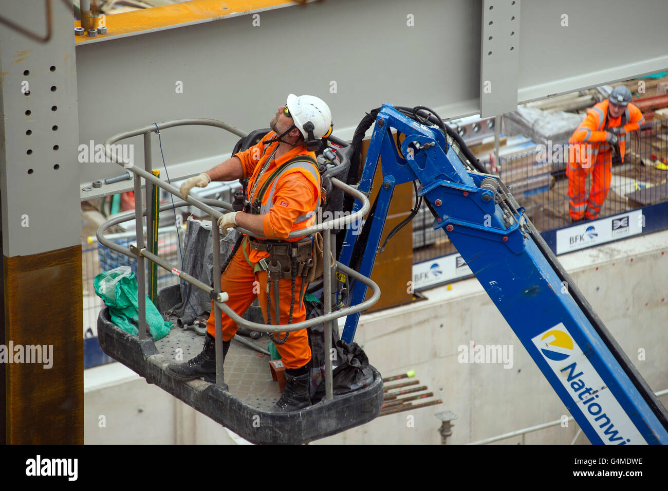 Construction worker in a hoist installing girders at the Eastern Ticket