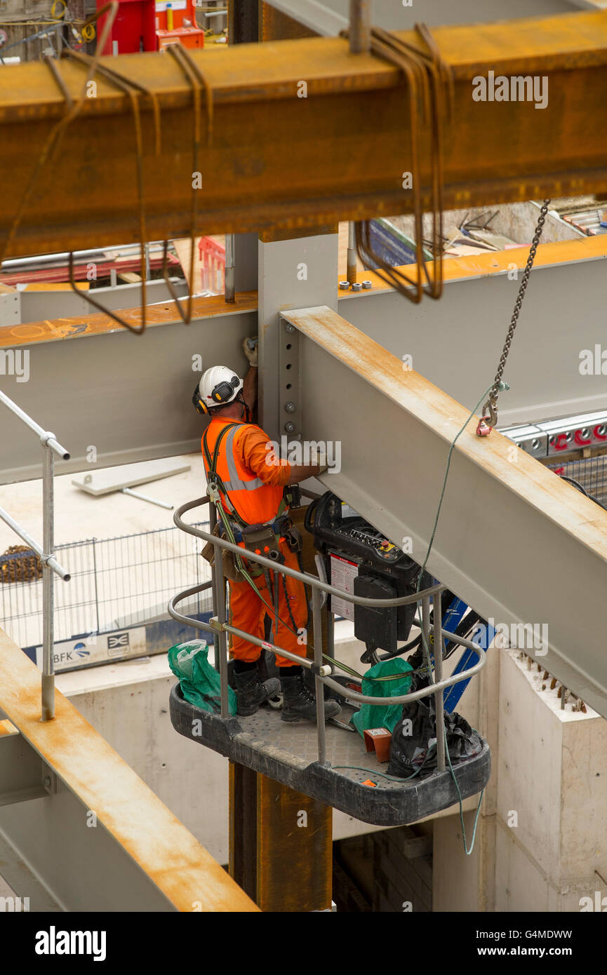 Construction worker in a hoist installing girders at the Eastern Ticket