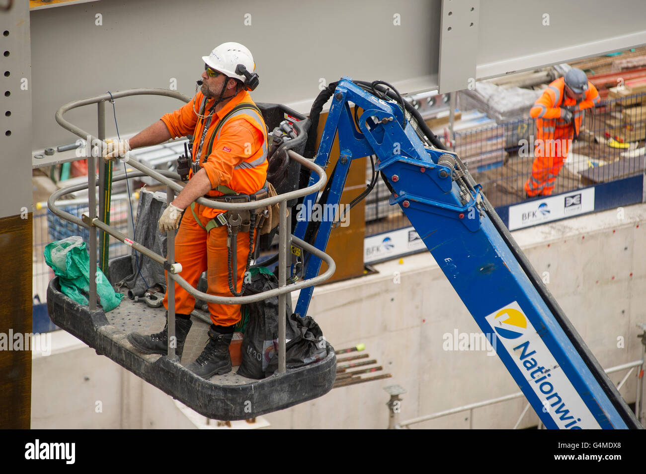 Construction worker in a hoist installing girders at the Eastern Ticket