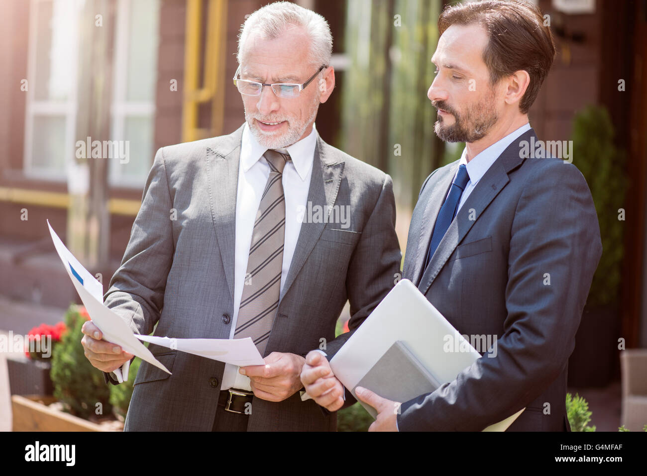 Serious colleagues standing together Stock Photo - Alamy