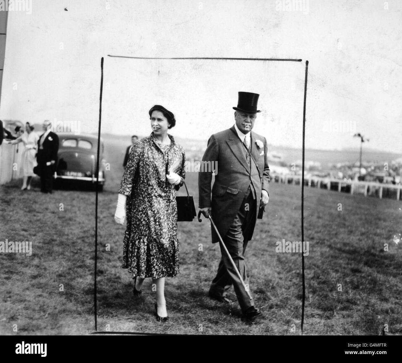 The Queen, accompanied by the Earl of Rosebery, walking to the paddock at Epsom where she watched the Oaks. Stock Photo