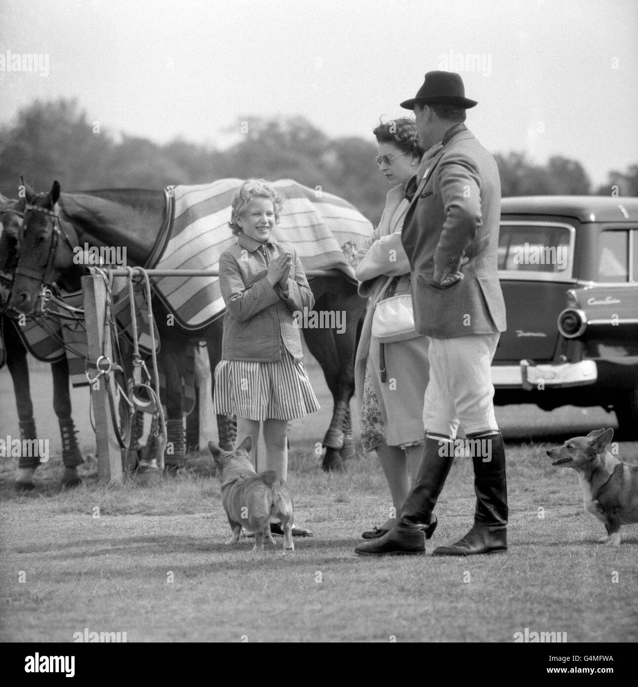 Queen Elizabeth II and her daughter Princess Anne with two royal corgi dogs at Smith's Lawn, Windsor Great Park. They were there to see the Duke of Edinburgh play polo. Stock Photo