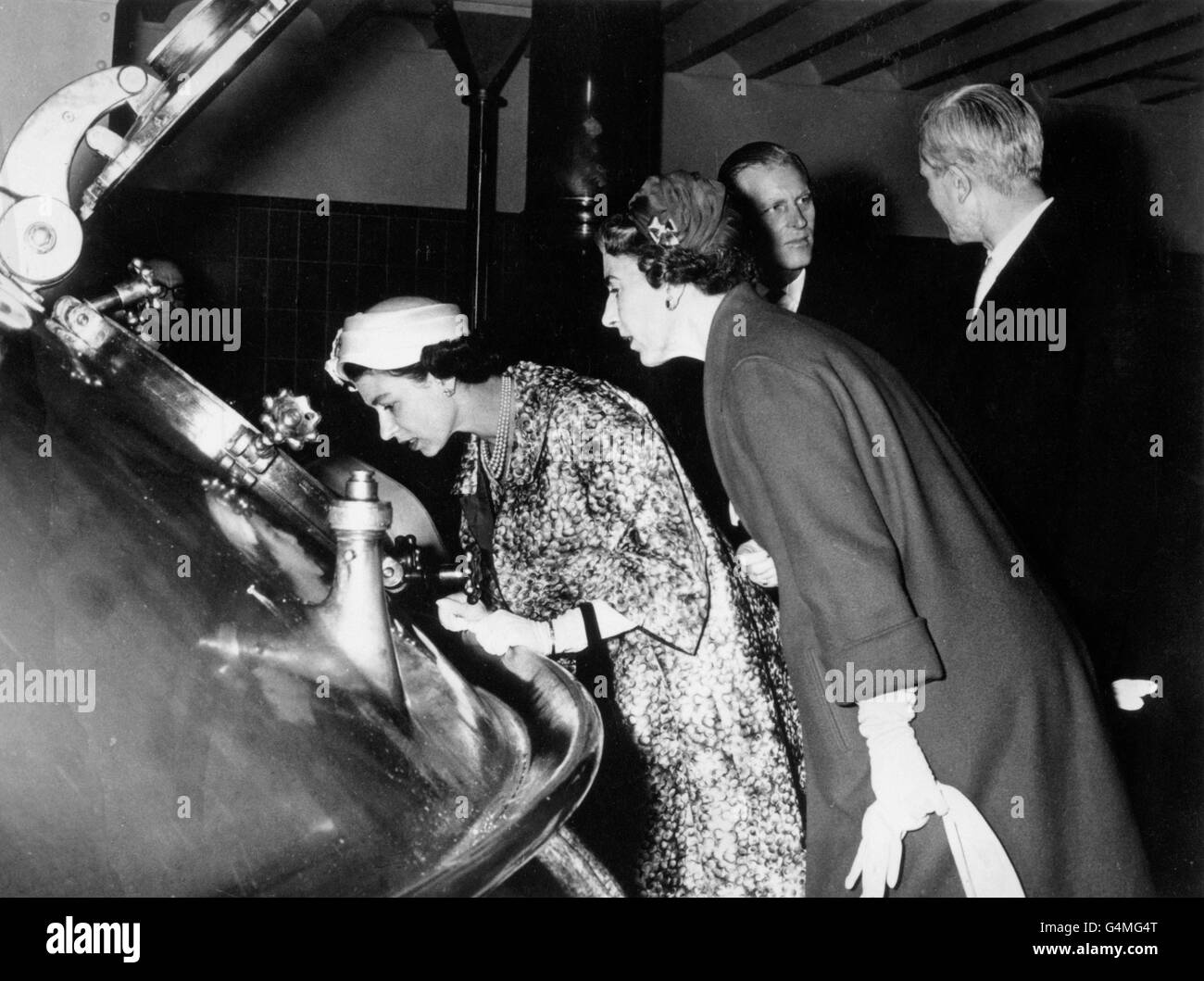 Two Queens - Elizabeth II of Great Britain and Ingrid of Denmark, right, peer into one of the huge vats at the Carlsberg Brewery in Copenhagen. Stock Photo