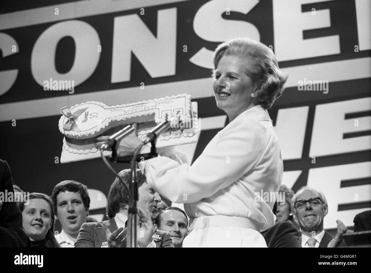 Margaret Thatcher holding up a birthday cake in the shape of a key with the words written on it 'No.10 Many Happy Returns Margaret'. Mrs Thatcher who is 53 today, was presented with the cake on the closing day of the Conservative Party Conference. Stock Photo