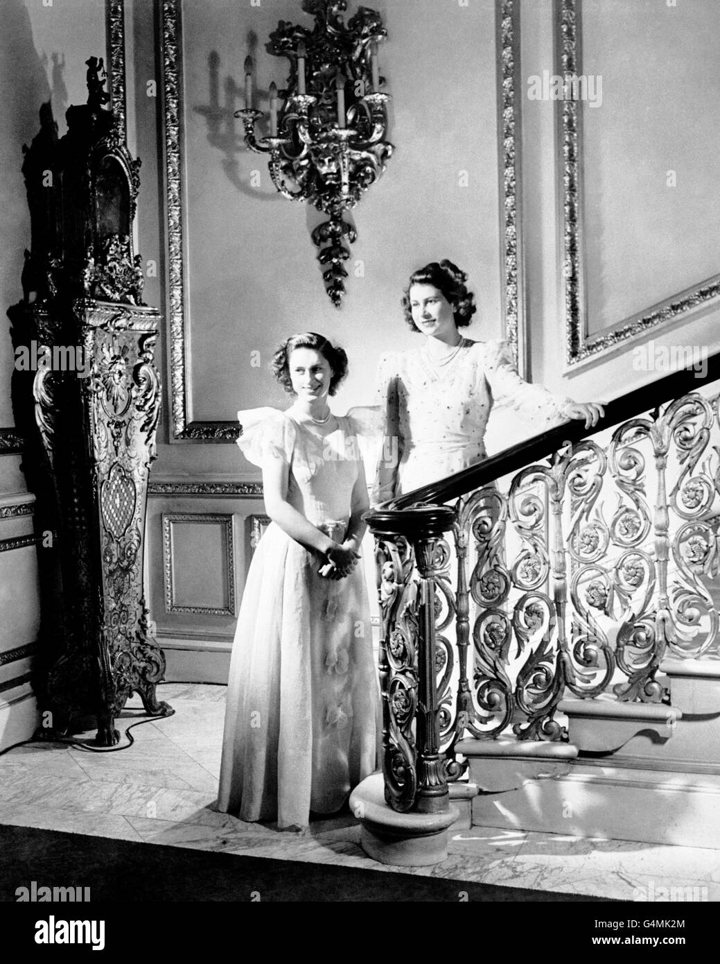 A Cecil Beaton photograph of Princess Elizabeth, right, and Princess Margaret as they pose by the staircase in Buckingham Palace Stock Photo