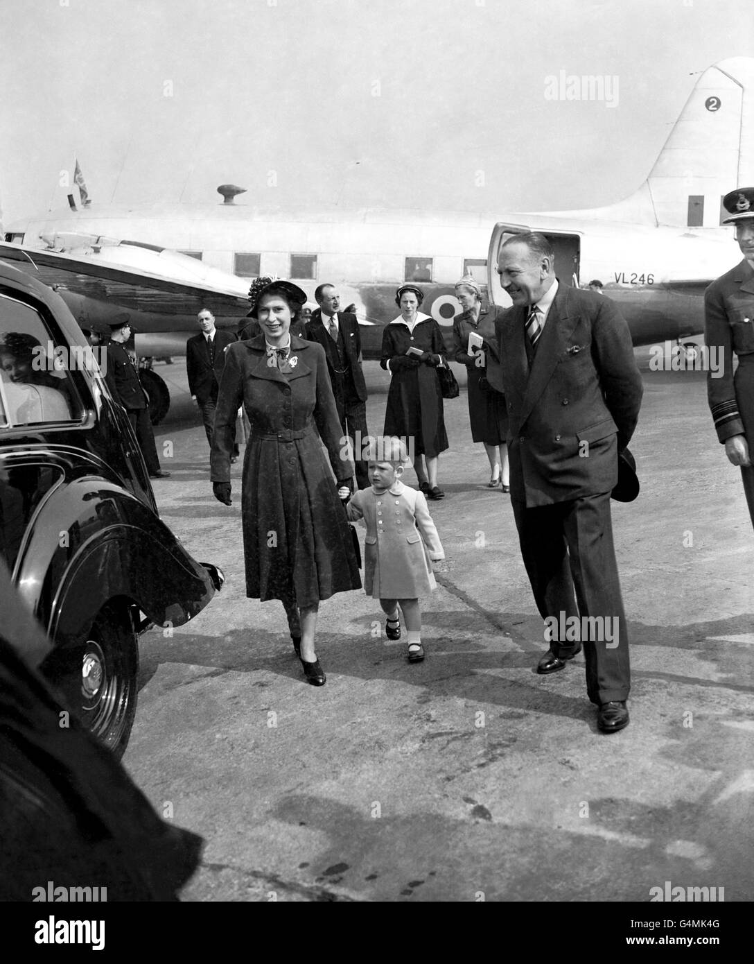 Prince Charles holds the hand of his mother, Princess Elizabeth, as they walked to the Royal car at Heathrow Airport, when the Princess returned home after her visit to Rome with the Duke of Edinburgh. Stock Photo