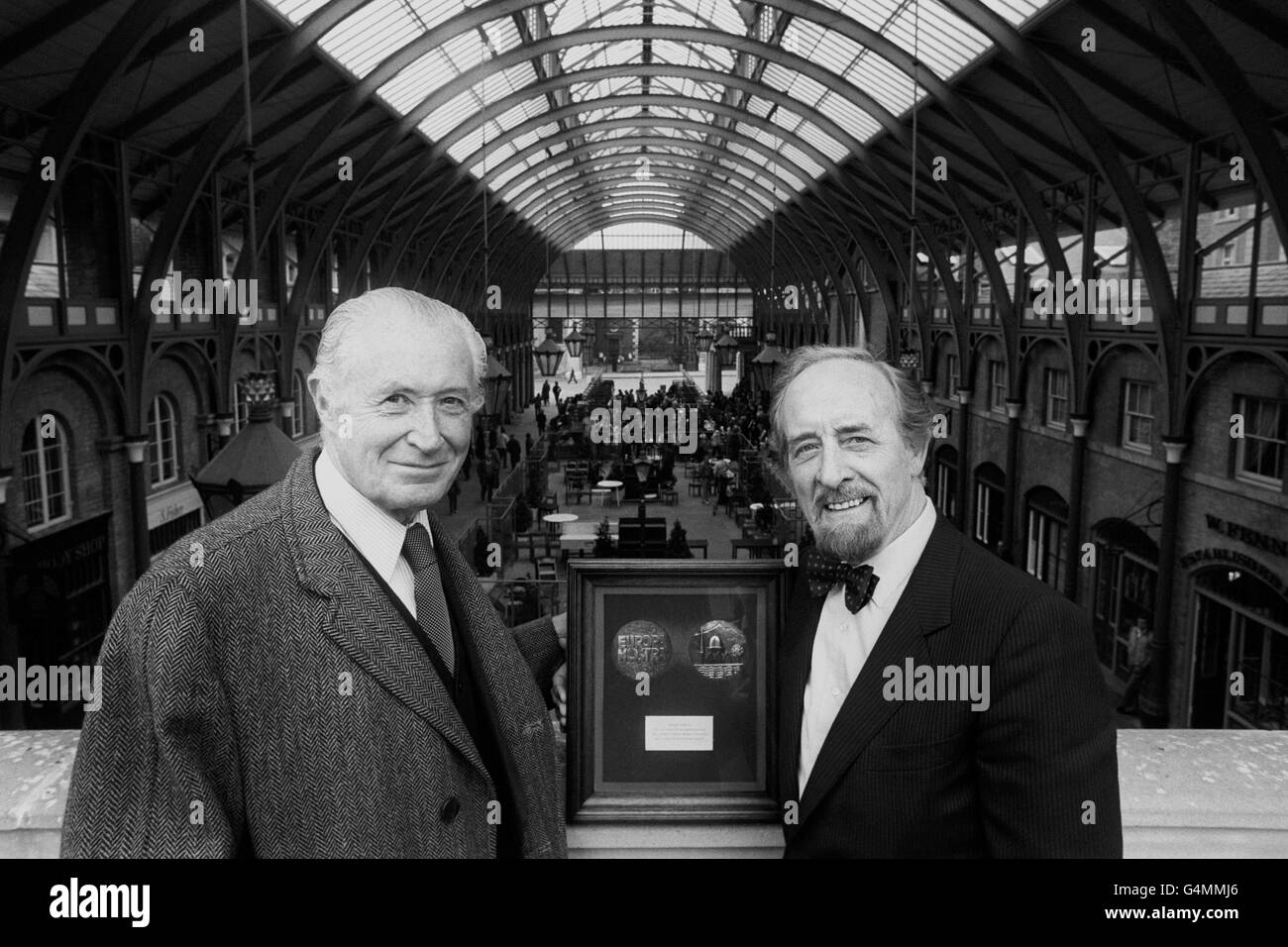 Lord Duncan-Sandys (l), president of Europa Nostra, after presenting the Europa Nostra medal to Sir Horace Cutler (r), leader of the Greater London council, at Covent Garden. The medal has been awarded to the GLC for the restoration of the former central market building (background). The award, designed and donated by Franklin Mint of London, consist of a specially minted medal mounted in a mahogany frame with a plaque bearing a description of the project. Stock Photo