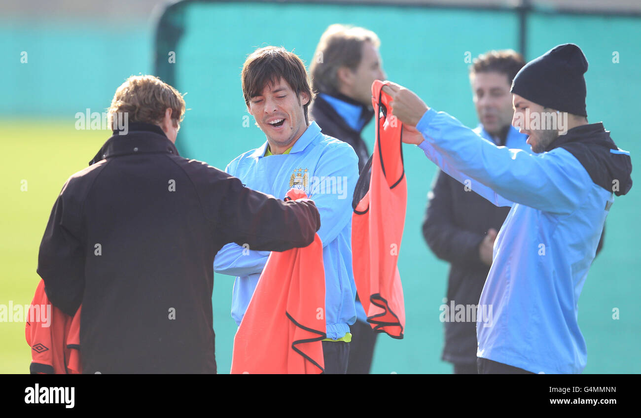 Manchester City's David Silva (2nd left) and Sergio Aguero (right) struggle with their bibs during training Stock Photo