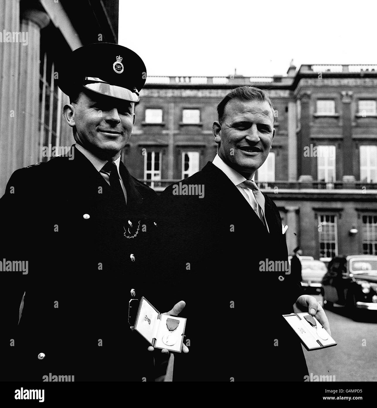 Metropolitan Police officers, Constable Michael Wheelhouse (left) and Detective-Sergeant Peter Woodmore, leave Buckingham Palace with the George Medals they received from the Queen for their part in the capture of a dangerous armed criminal. * After a chase which started in Parliament Square, PC Wheelhouse was shot in the arm before Sergeant Woodmore crashed the criminal to the ground with a 10ft leap in the grounds of a Kensington house. Stock Photo
