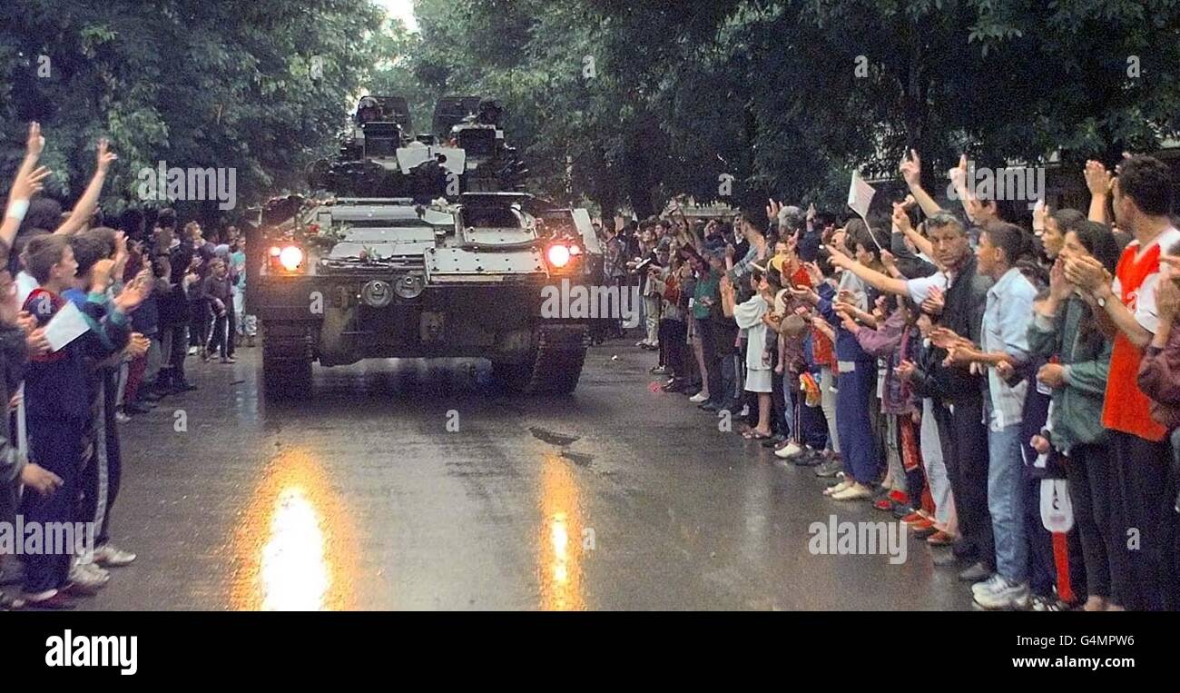 A British Warrior tank is cheered by Albanian townspeople in the centre of Podujevo, Kosovo, as British troops move in as part of the NATO peace-keeping force. Stock Photo