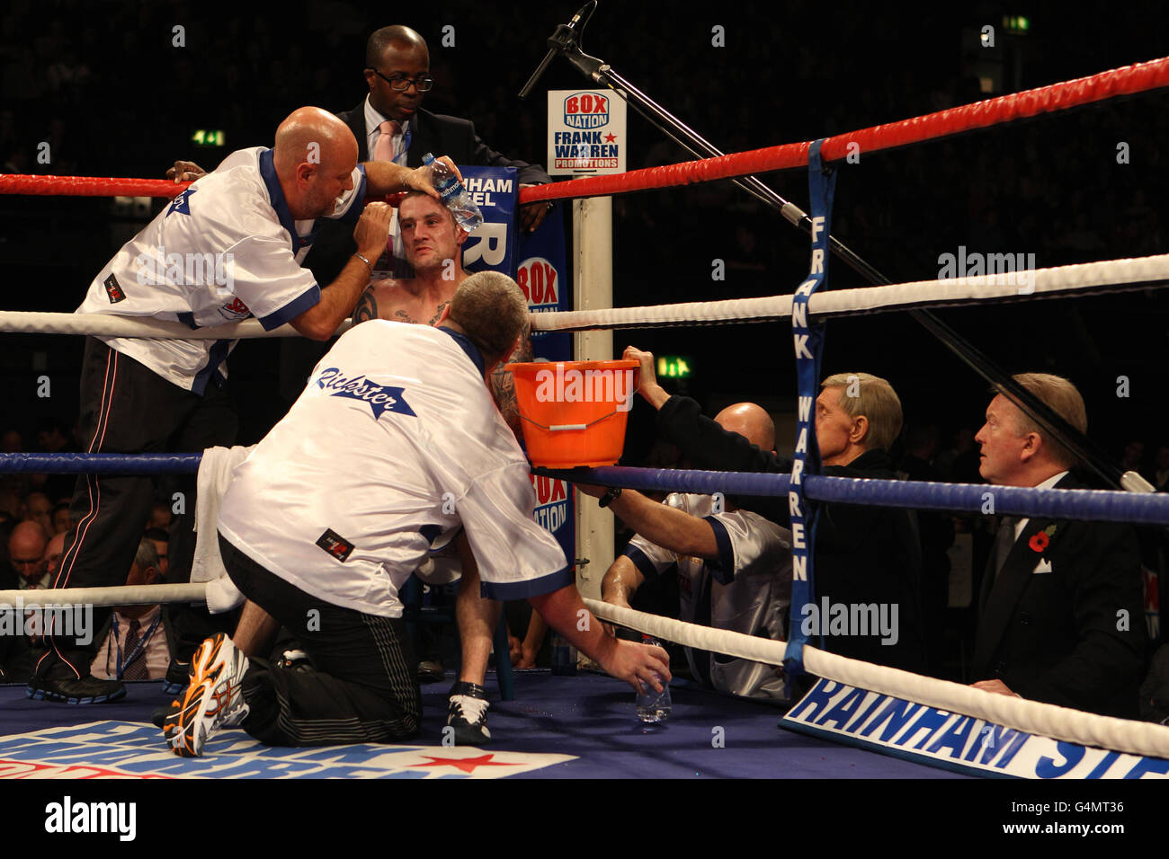 Scotland's Ricky Burns is looked after his corner as promoter Frank Warren shouts advice during his points victory over Australia's Michael Katsidis during the WBO Interim Lightweight Title fight at Wembley Arena, London. Stock Photo