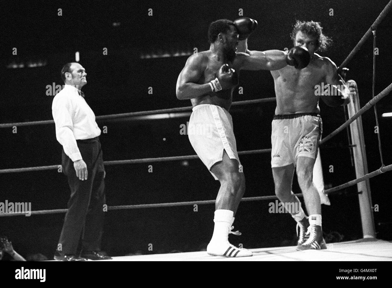 Ex-heavyweight champion of the world, Joe Frazier, left, of the USA, in action against Britain's Joe Bugner. Watching is referee Harry Gibbs. Stock Photo