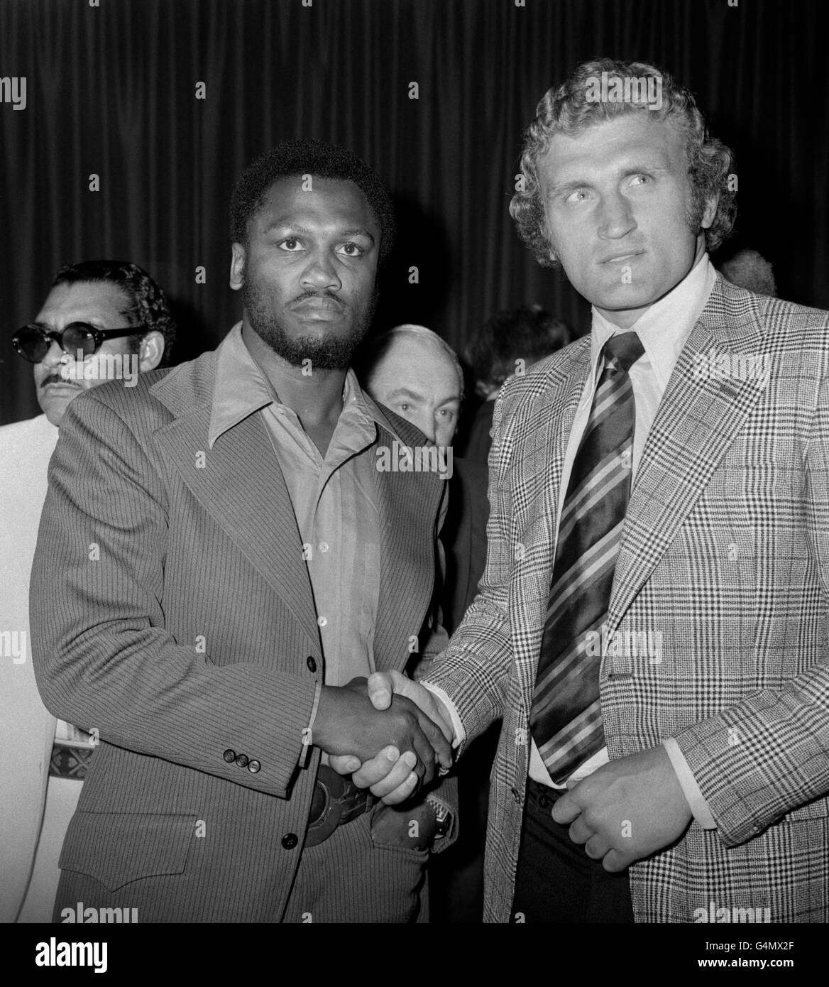 'Smokin' Joe Frazier (l) shakes hands with Joe Bugner (r) at a press conference ahead of their fight to be held at Earls Court, London, on July 2nd. Joe Frazier would go on to win that fight on points after 12 rounds. Stock Photo