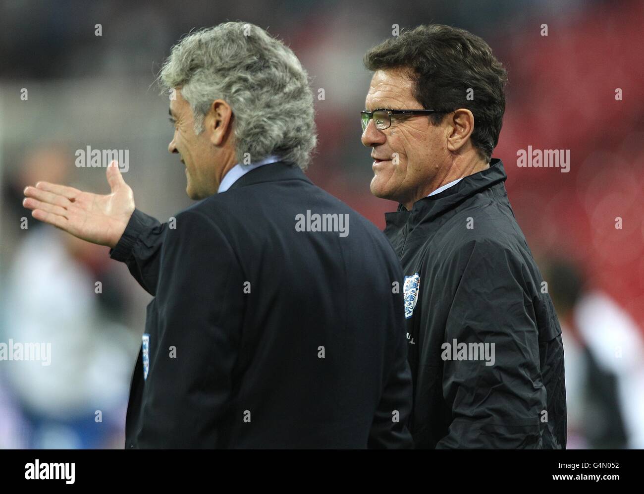 England manager Fabio Capello (right) discusses tactics with general manager Franco Baldini before the match Stock Photo