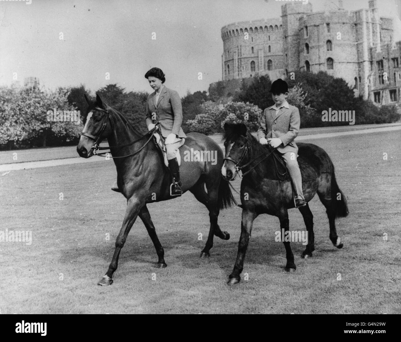 Queen Elizabeth II and her son, the Prince of Wales, out riding at Windsor Castle. Stock Photo