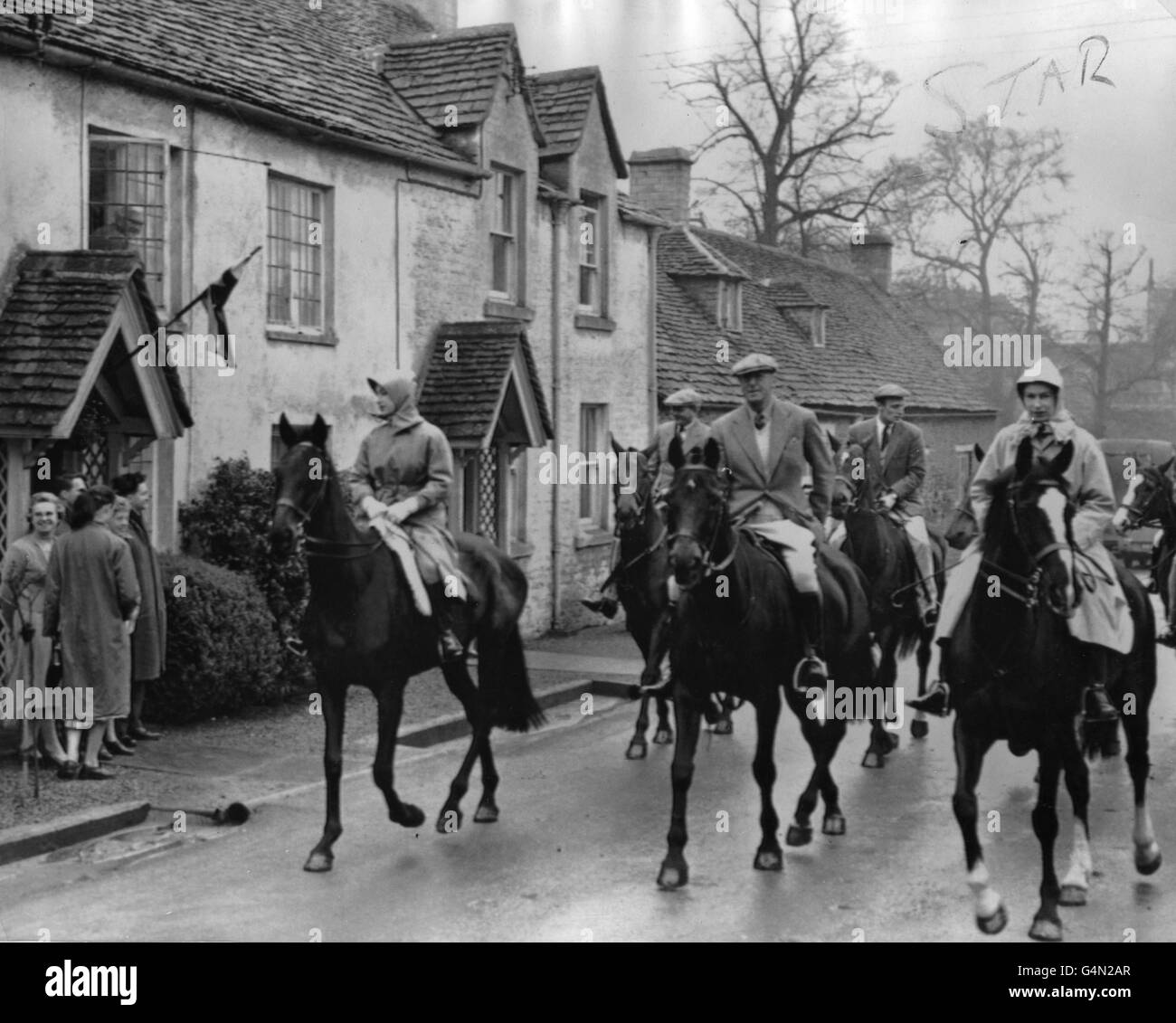 Dressed against the rain, the Queen, right, and Princess Margaret leave Badminton House with the Duke of Beaufort for a ride through Badminton Great Park. Stock Photo