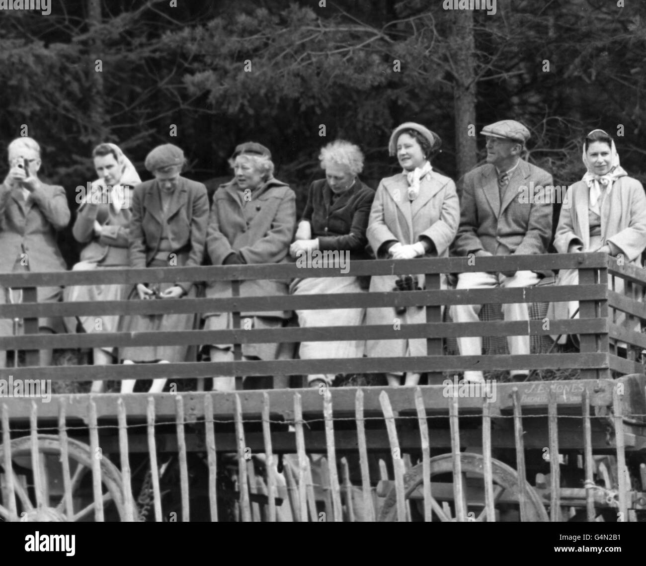 Queen Elizabeth II, right, the Duke of Beaufort and the Queen Mother use a farm wagon as a 'grandstand' at the Quarry Jump during the Three Day Horse Trials at Badminton. Stock Photo