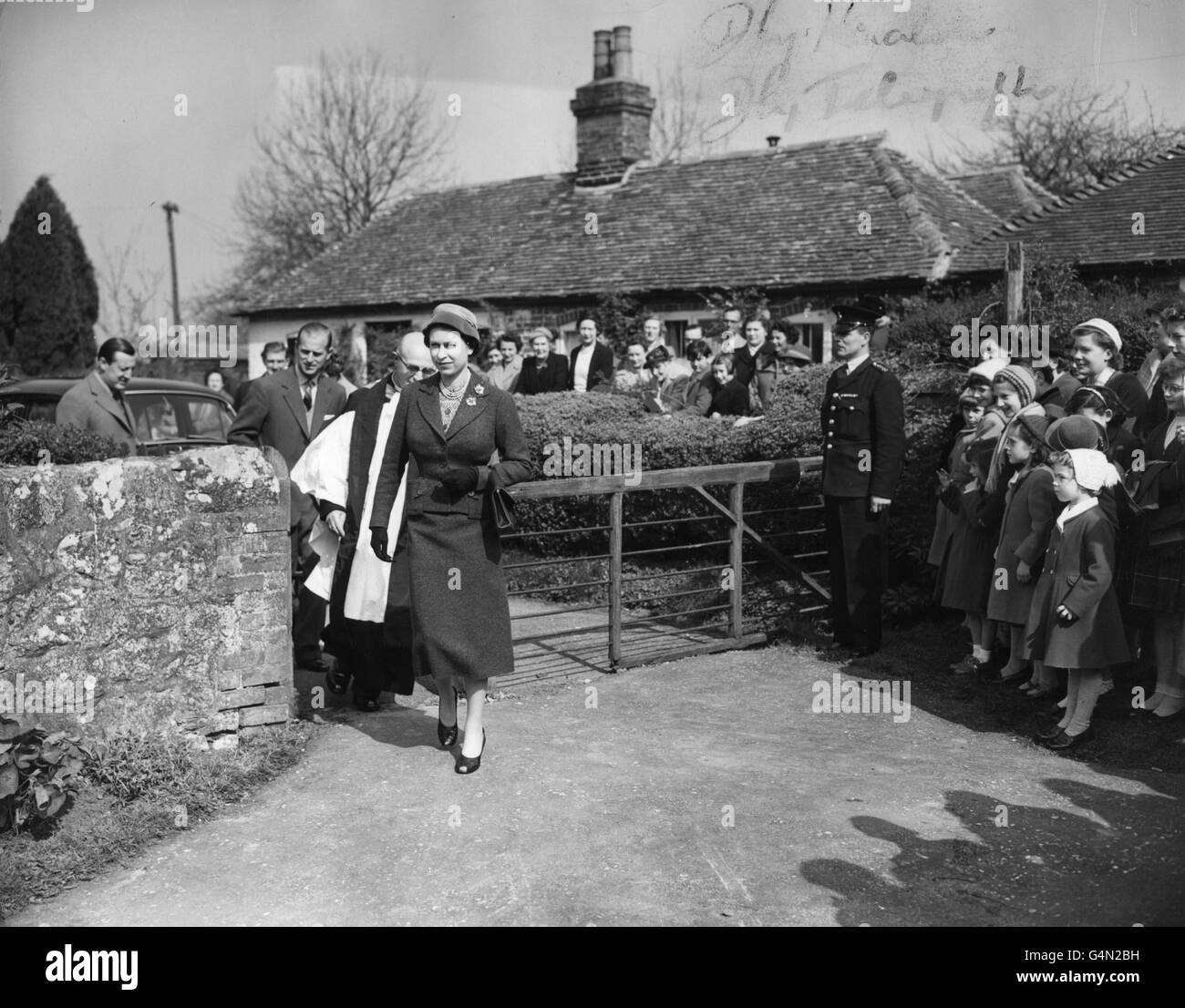 Queen Elizabeth II, accompanied by the vicar, the reverend H.L McDonald Liegeois, after attending morning service at the 11th century church at Mersham, near Ashford in Kent. The Queen and Duke of Edinburgh are the guests of Lord and Lady Brabourne at Mersham. Stock Photo