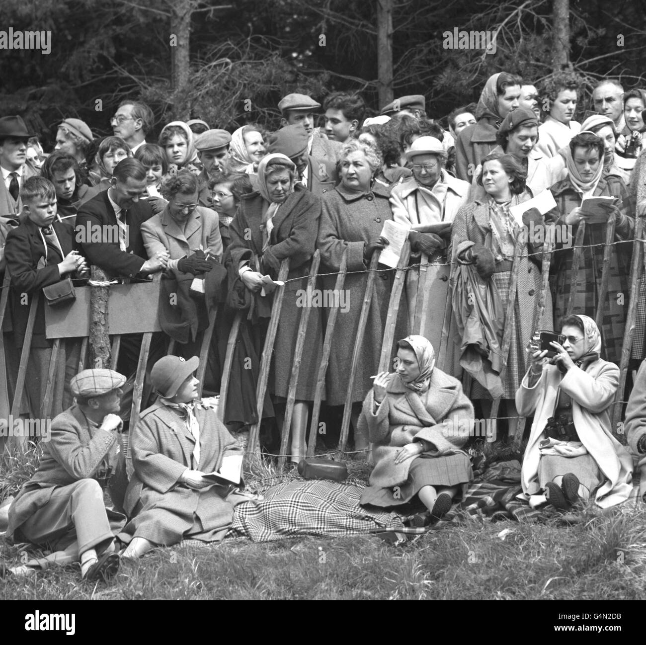 Queen Elizabeth II films competitors at the Quarry Jump in the cross country course at the Badminton horse trials. With her, left to right, are the Duke of Beaufort, the Queen Mother and Princess Margaret. Stock Photo