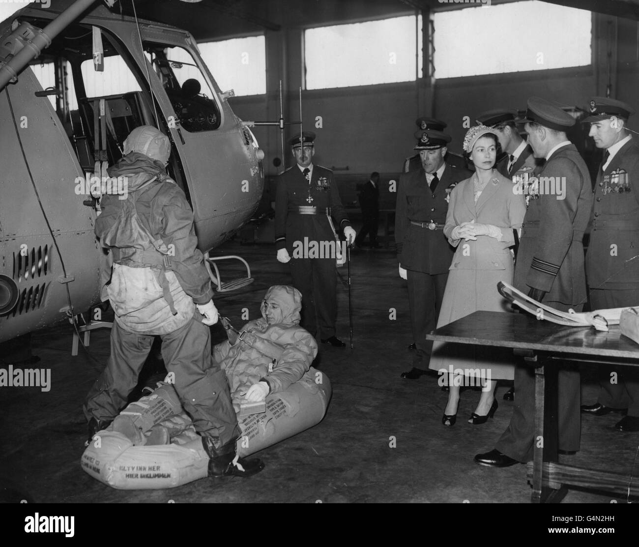 Queen Elizabeth II, with the Duke of Edinburgh, watches a helicopter demonstration of rescue by winch, give by Flight-Lieutenant J. Major and Pilot Officer J. Perry, during the visit to RAF Leuchars, Fife, Scotland. Stock Photo