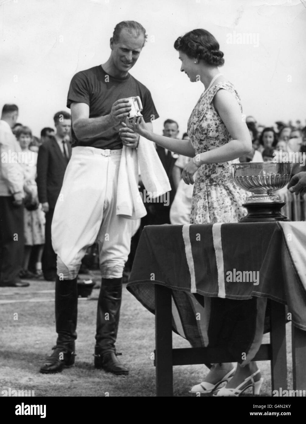 Queen Elizabeth II presents a tankard to her husband, the Duke of Edinburgh, a member of the winning Friar Park team in an invitation polo match against Silver Leys on Smith's Lawn, Windsor Great Park. Stock Photo