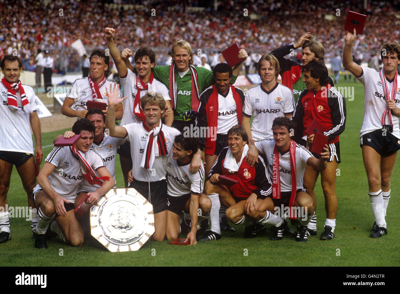 The Manchester United team celebrate with the Charity Shield after beating Liverpool 2-0. (back l-r) Ray Wilkins, Mike Duxbury, Bryan Robson, Gary Bailey, Remi Moses, Arthur Graham, Jeff Wealands, Lou Macari and Norman Whiteside. (Front l-r) Frank Stapleton, John Gidman, Gordon McQueen, Arthur Albiston, Arnold Muhren and Kevin Moran. Stock Photo