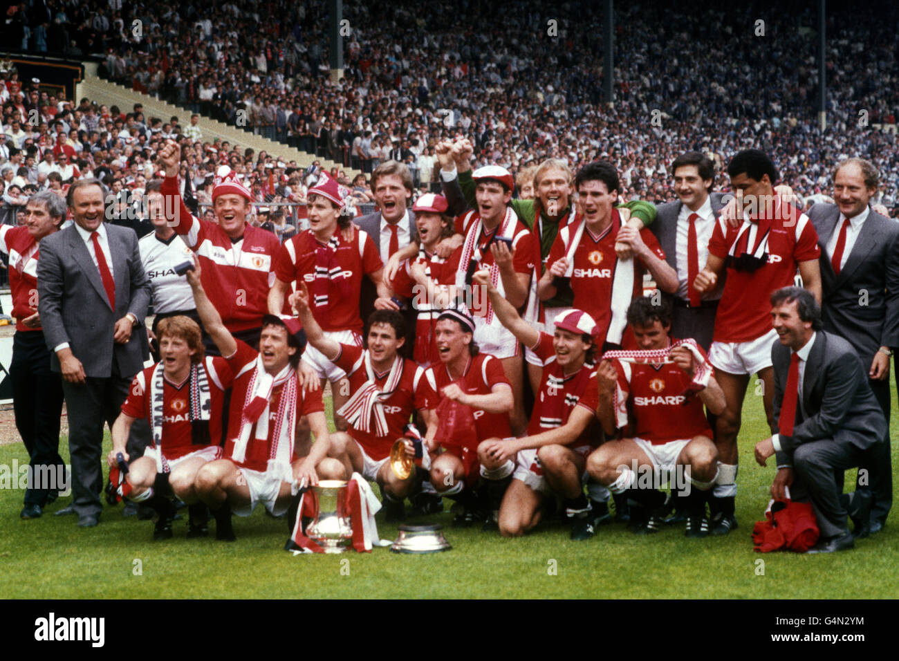 Manchester United celebrate with the FA Cup after beating Everton 1-0 in the final. (back l-r) Ron Atkinson, unknown, unknown, Mark Hughes, Gordon McQueen, Jesper Olsen, Norman Whiteside, unknown, Gary Bailey, Frank Stapleton, Greame Hogg, Paul Grath, and Gary Brazil. (front l-r) Gordon Strachan, John Gidman, Arthur Albiston, Mike Duxbury, Bryan Robson and Kevin Moran. Stock Photo