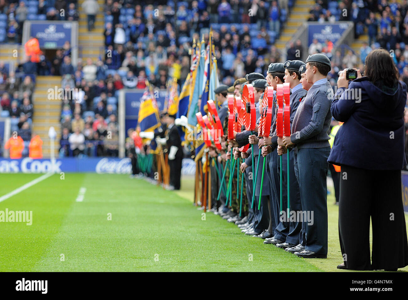 Members of the armed force hold giant poppies in a line inside the King Power Stadium prior to kick-off Stock Photo
