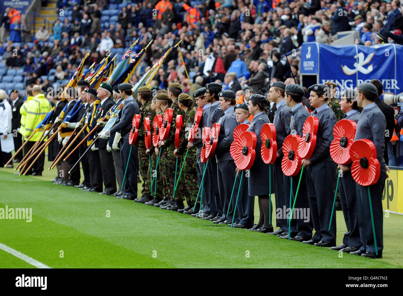 Soccer - npower Football League Championship - Leicester City v Leeds United - King Power Stadium. Members of the armed force hold giant poppies in a line inside the King Power Stadium prior to kick-off Stock Photo