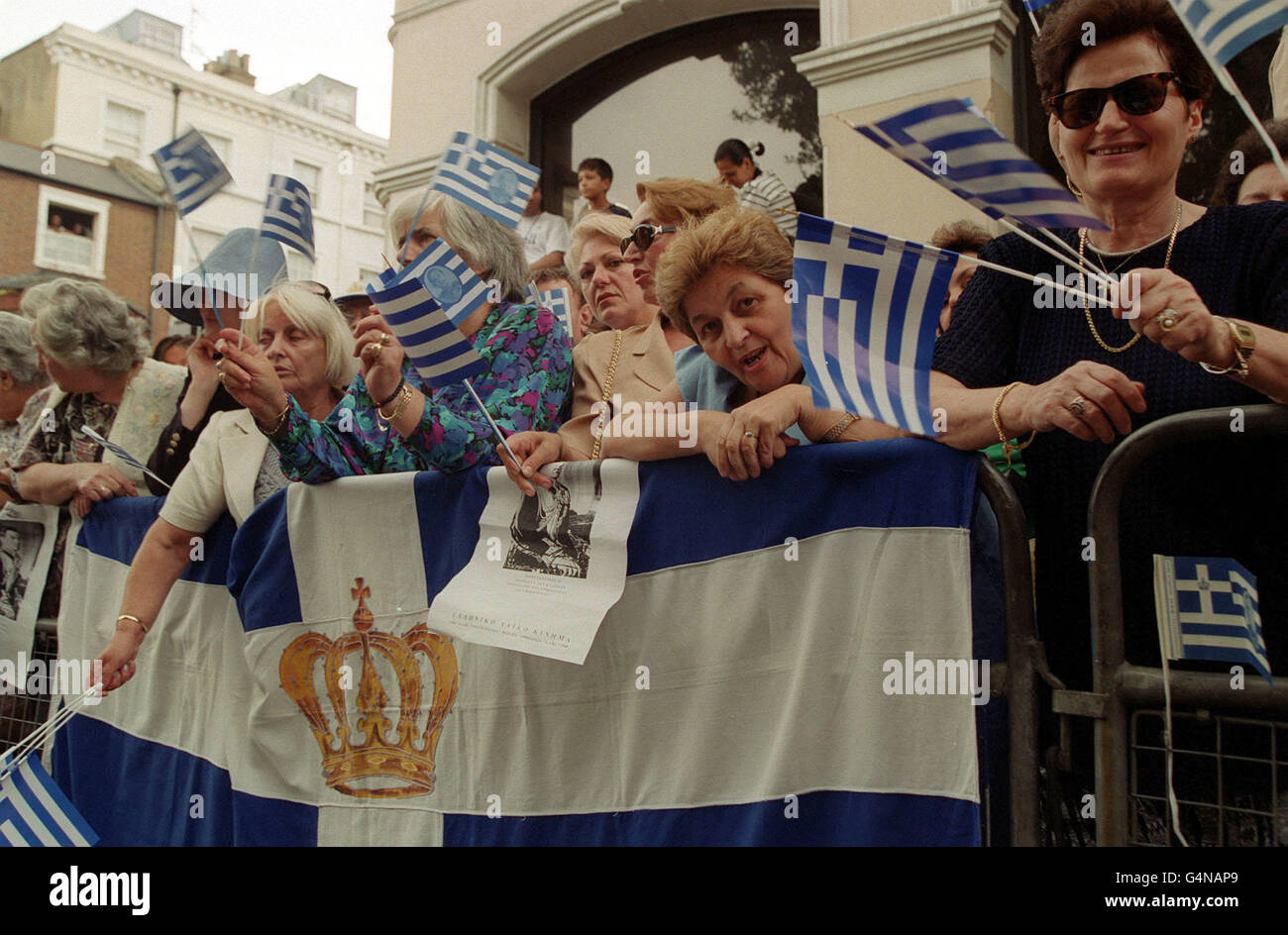 Supporters of the Greek royal family wave flags as they gather outside the Greek Orthodox Cathedral of St Sophia in Bayswater, west London, where the wedding service of Princess Alexia of Greece and Carlos Morales Quintana of Spain was being held. Stock Photo