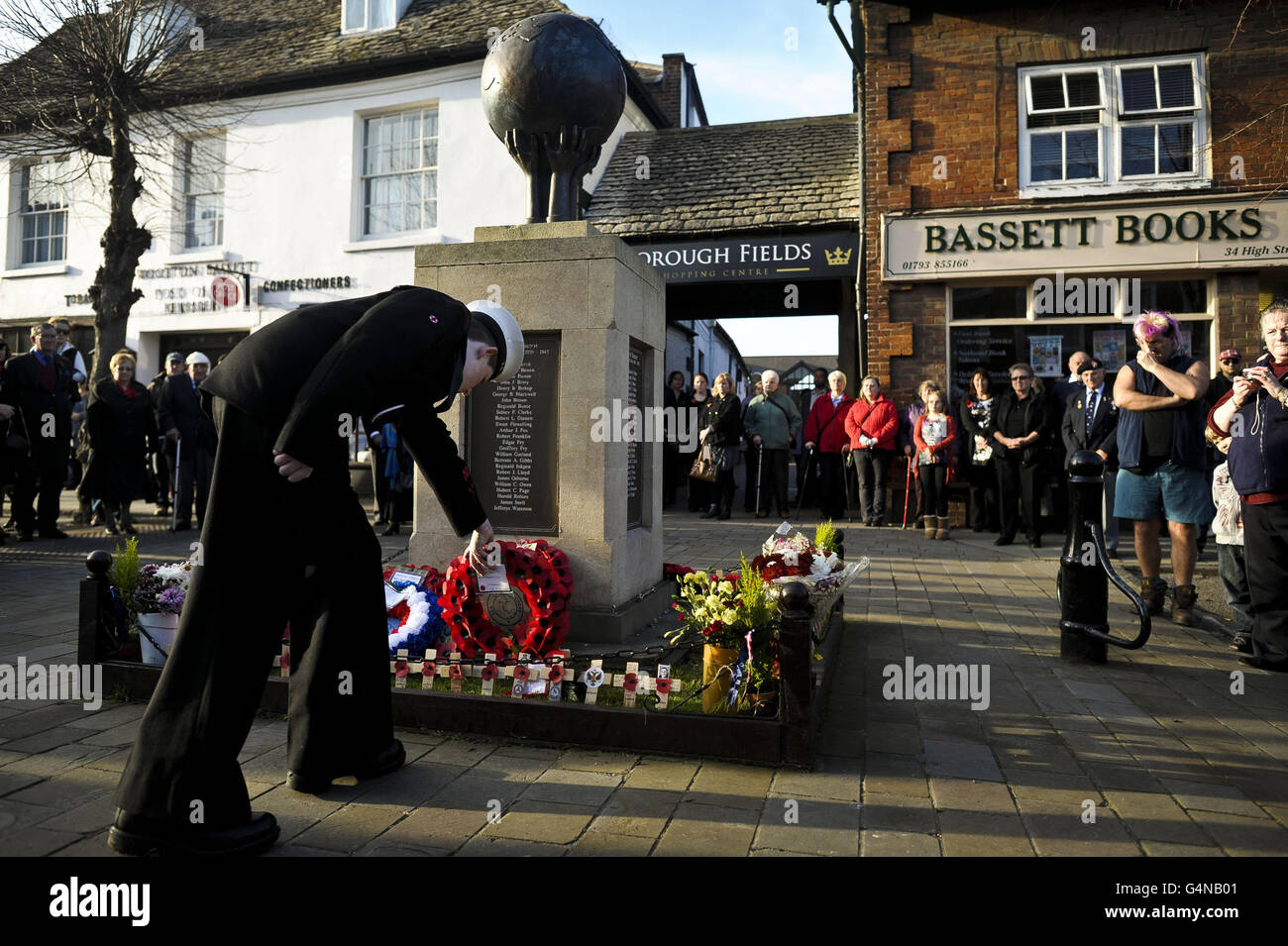 A sea cadet places a wreath by the war memorial at Royal Wootton