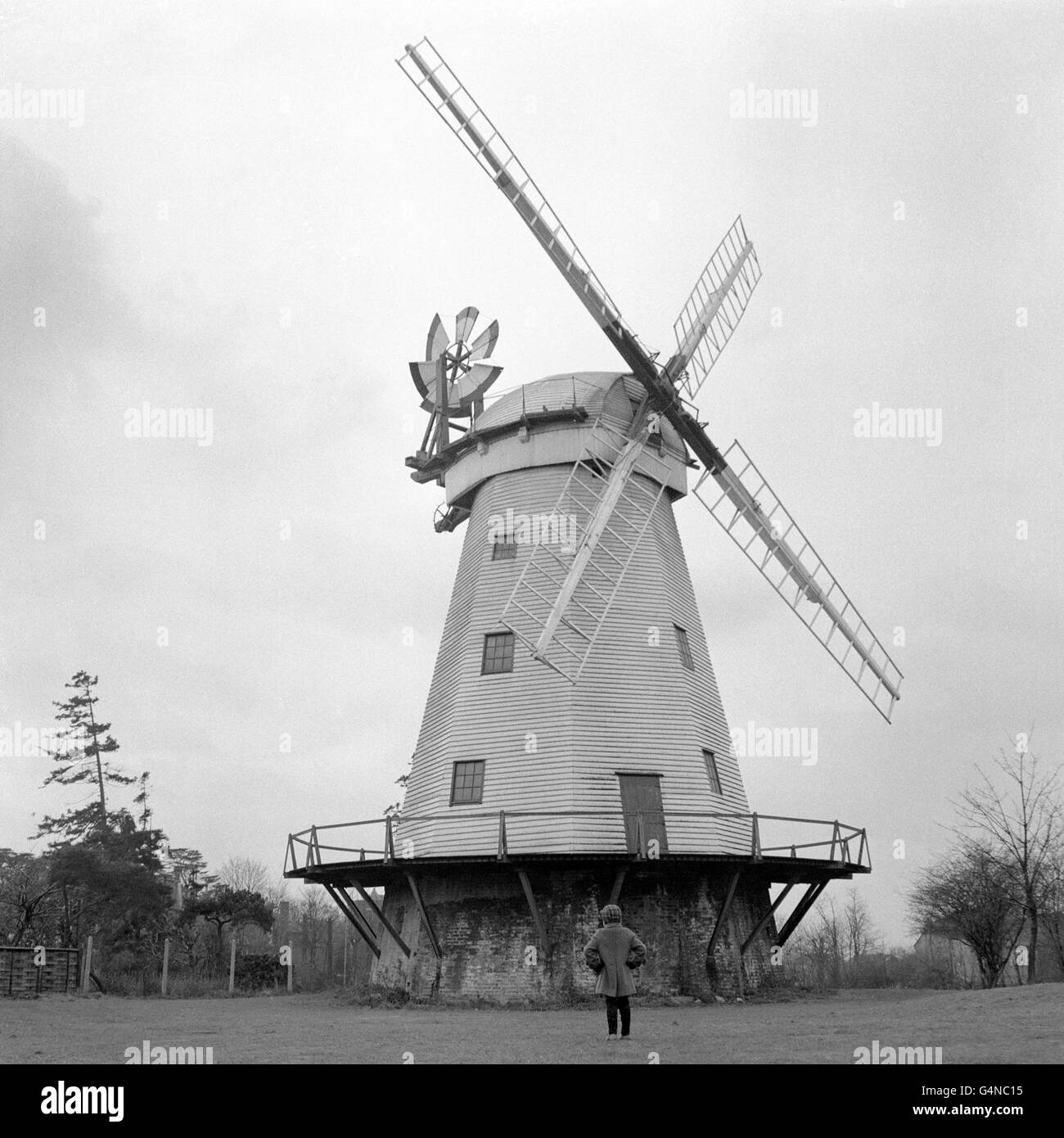 Time stands still for this giant windmill at St Mary's Lane, Upminster, Essex. It often stops the traffic to the coast as motorists stop to admire it. Built inn 1802 by James Nokes, the windmill used a steam engine powerful enough to work five pairs of stones. Young Robert Stolworthy of Romford, Essex, stands and admires this giant from the past, which is no longer used as a corn-mill. Stock Photo