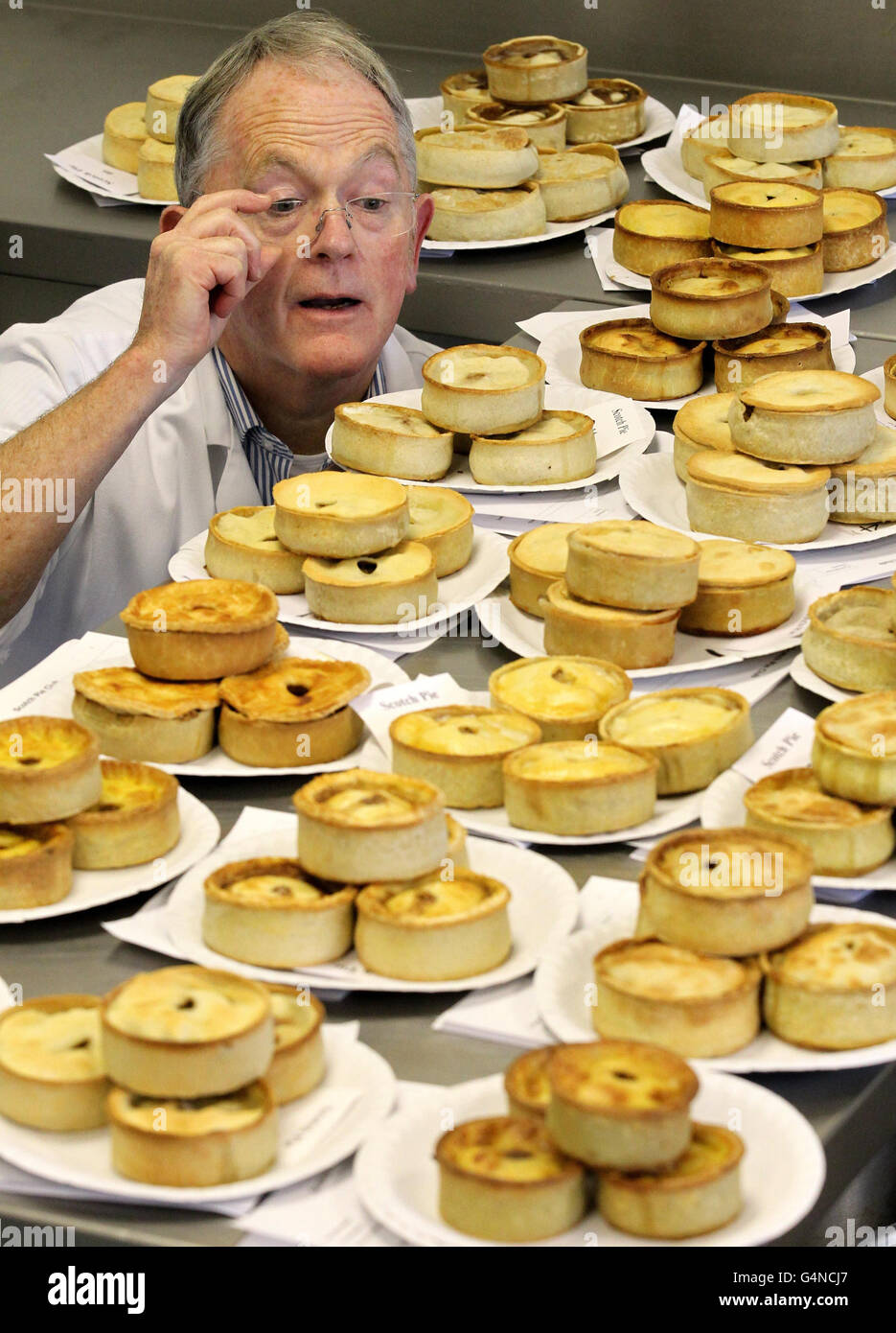 Chief judge Robert Ross judges the pies during the World Scotch Pie Championship at Carnegie College in Dunfermline. Stock Photo
