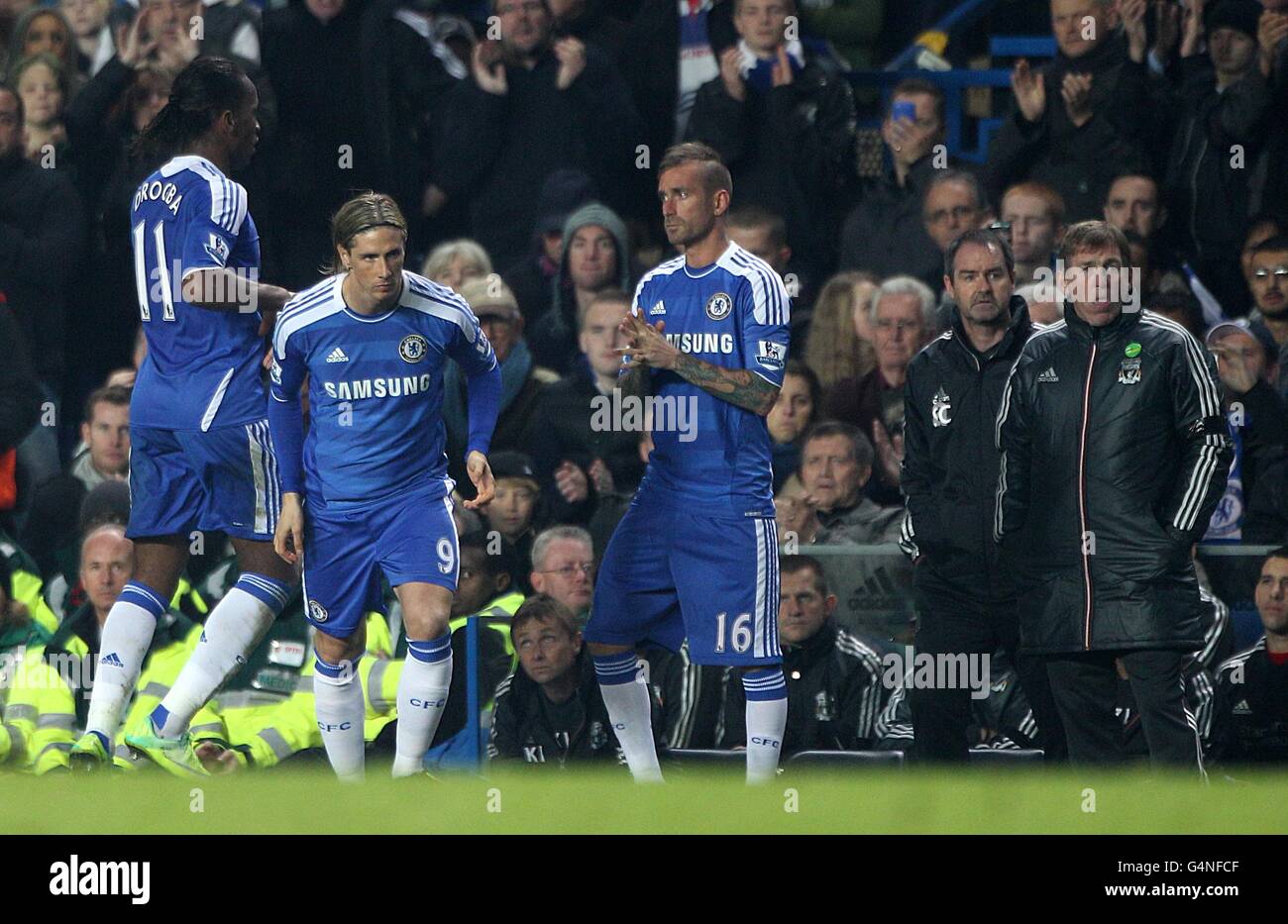 Liverpool manager Kenny Dalglish (right) and first team coach Steve Clarke look on as Chelsea's Didier Drogba (left)) is substituted on as Fernando Torres (2nd left) and Raul Meireles (3rd right) are substituted on Stock Photo