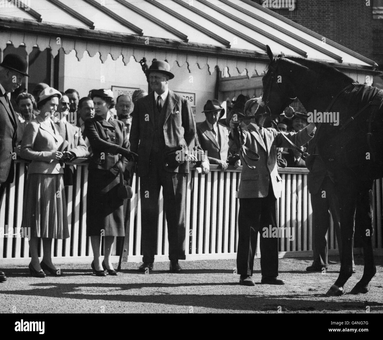 Princess Margaret listens as the Queen points to her colt Doutelle, who had just won the 2,000 Guineas Trial Stakes at Kempton Park races Stock Photo