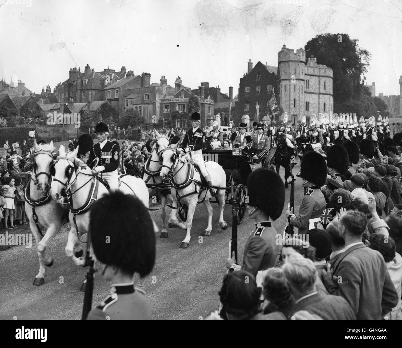 Queen Elizabeth II, accompanied by the Duke of Edinburgh, drives past ...