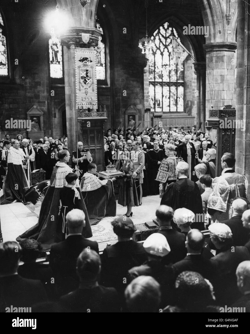 Queen Elizabeth II returning the crown of the Scottish Crown jewels to the care of the Duke of Hamilton, in St. Giles' Cathedral, Edinburgh, during the Scottish National Service of Thanksgiving and Dedication. The Crown of the Scottish Crown Jewels went on procession for the first time since 1822. The Duke of Edinburgh, in Field Marshall's uniform and plumed hat, is seen behind the Queen. Stock Photo