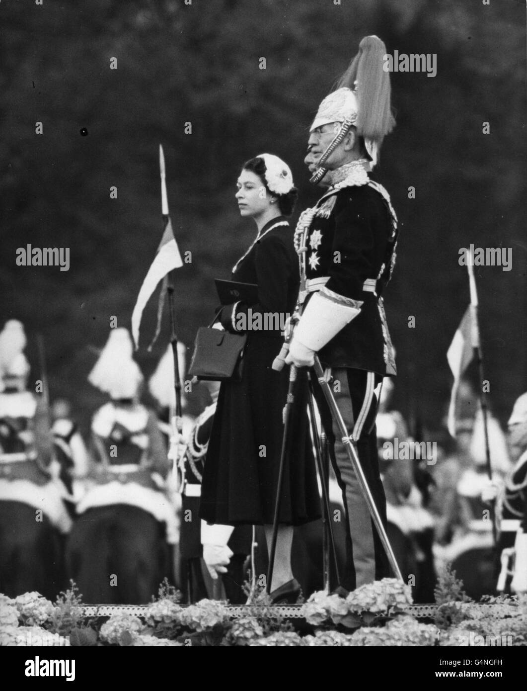 Queen Elizabeth II standing with Household Cavalry officers as she takes the salute at the march past, after she had presented new Colours to the Household Cavalry (The Life Guards and the Royal Horse Guards), at Windsor Castle. Stock Photo