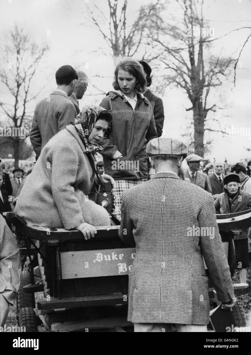 Queen Elizabeth II talks to her host, the Duke of Beaufort from a farm cart 'grandstand', during the Speed and Endurance course of the Three day Horse Trials at Badminton. With the Queen on the cart is Princess Anne. Stock Photo